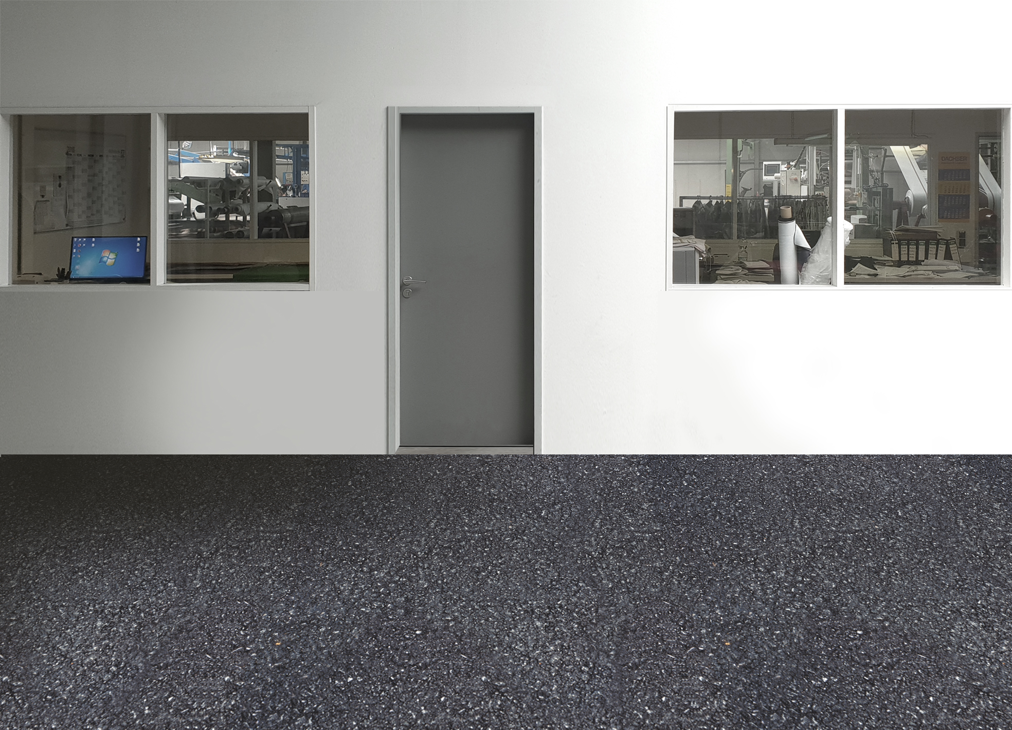 Schwarzer, strapazierfähiger Industrieboden vor weißer Wand mit Tür und Fenstern in einer Produktionshalle