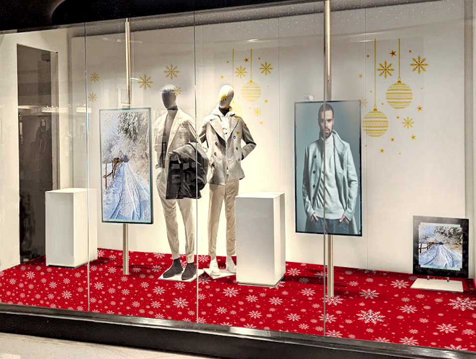 Schaufenster mit Modepuppen, roten Schneeflocken-Bodenaufklebern und goldenen Weihnachtsmotiven als festliche Dekoration für den Einzelhandel