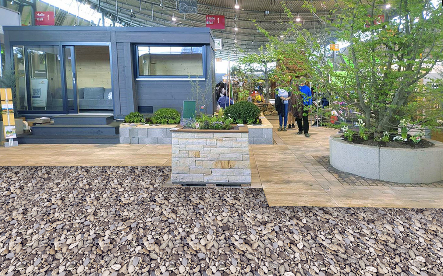 Ausstellungsfläche für Garten- und Terrassengestaltung mit Holzdeck, Kiesbelag, bepflanzten Hochbeeten, Baumrondell und modernem Gartenhaus.