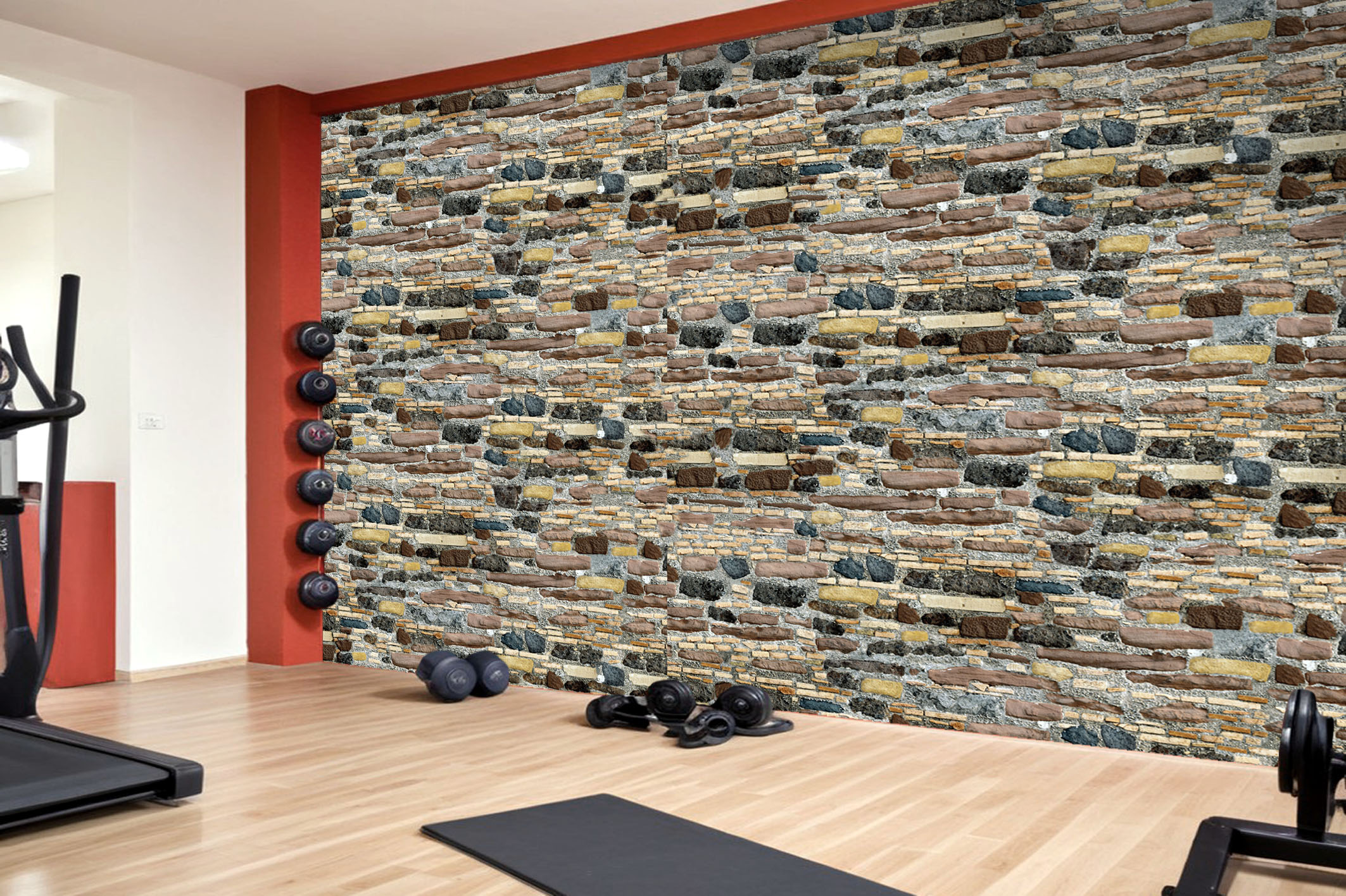 Fitnessraum mit Akzentwand in realistischer Steinoptik-Tapete, kombiniert mit roten Wandflächen, Holzboden und Trainingsgeräten
