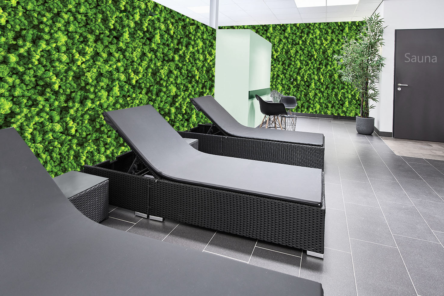 Moderner Wellnessbereich mit schwarzen Relaxliegen vor einer grünen Mooswand, ideal als dekorative Wandbegrünung für Sauna- und Spa-Räume