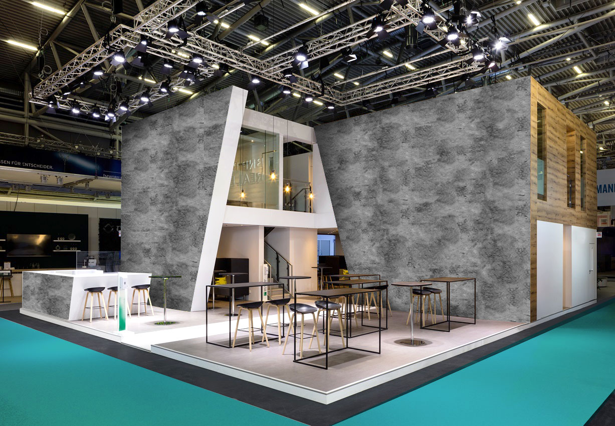 Großer moderner Messestand mit Betonoptik-Wänden, Holzverkleidung, Theken, Sitzbereichen und Beleuchtung in einer Messehalle